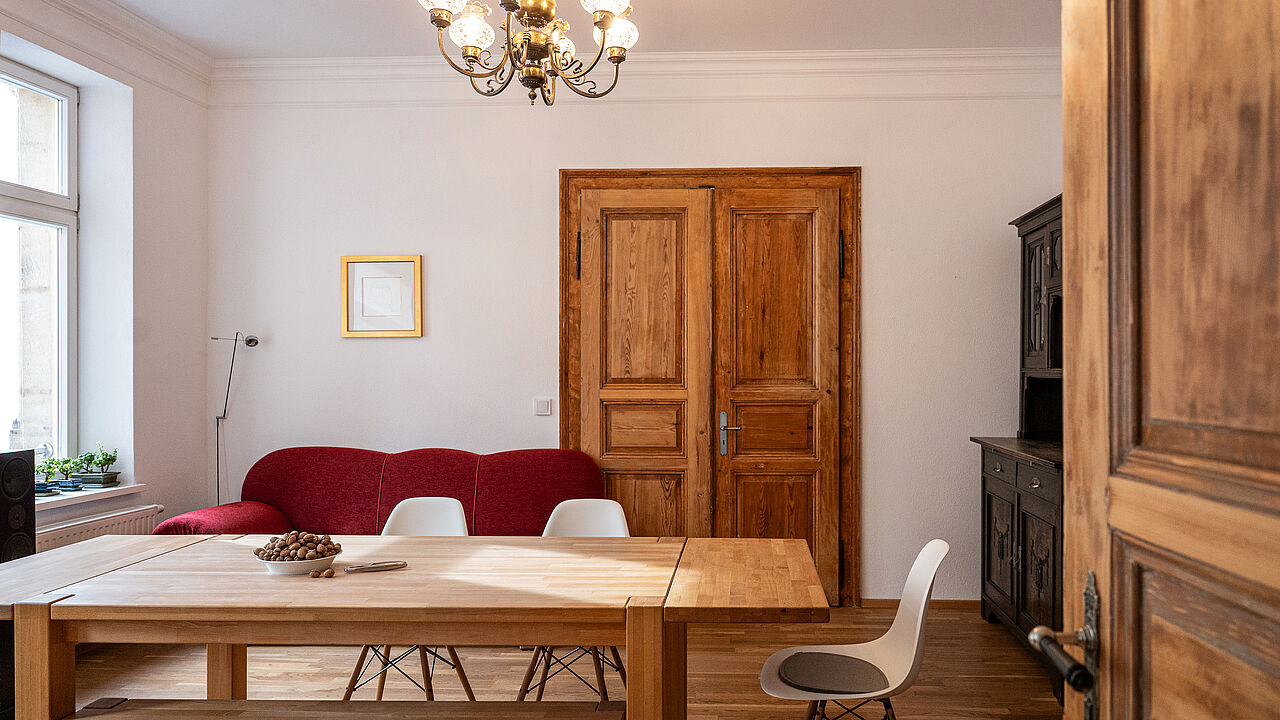 Wohnzimmer mit typischen Altbauelementen wie Flügeltüren 